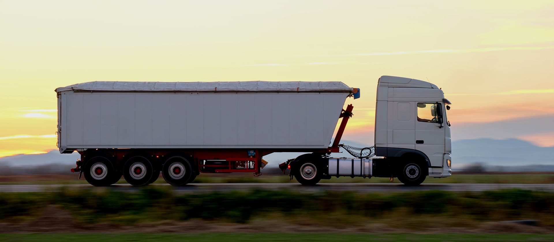 Carreta de carga trafegando em rodovia ao entardecer